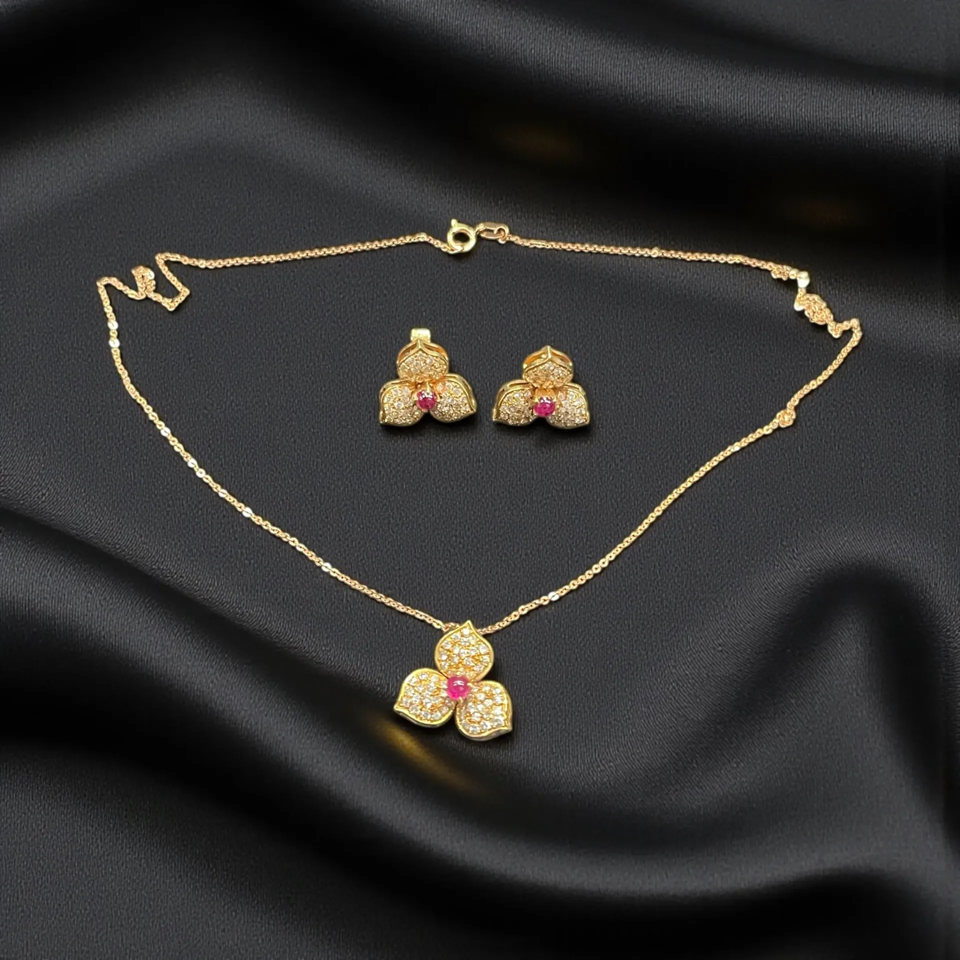 A 14ct rose Gold Ruby and Diamond floral cluster earrings and pendant set