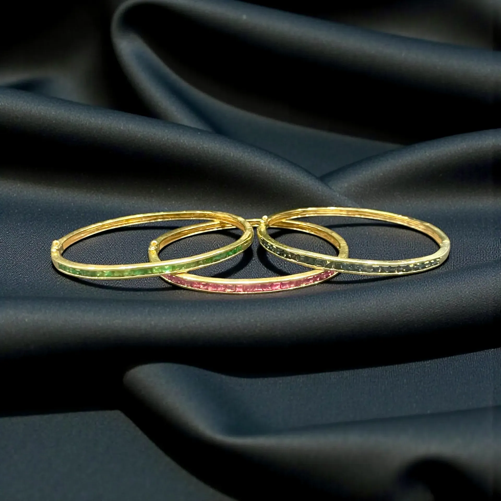 An 18ct yellow Gold and Emerald, Ruby, Sapphire bangles. Individual Valuation and Pricing.